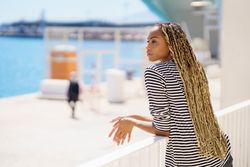 Female leaning on railing of the pier watching the water