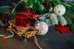 Fir and holiday decorations on dark table