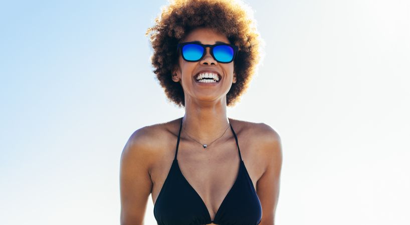 Attractive young woman in bikini against bright sky