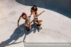 Top view of three young women laughing and having fun at skate park 48OYk5