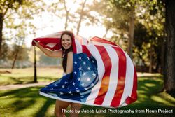 Patriotic woman with American flag in the park 4AOOQ0