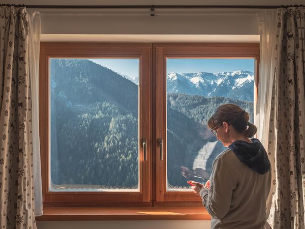 Woman browsing smartphone near window