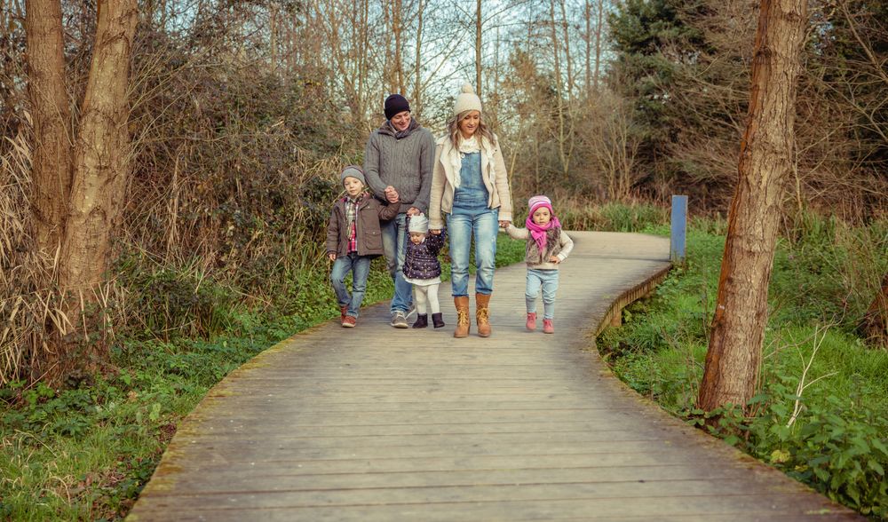 Family of 5 walking along forest trail