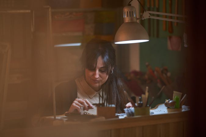 Focused female jeweler checking new created accessories