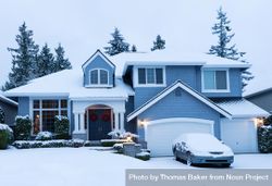 Front of suburban home decorated for the holidays with fresh snow 0V28X0