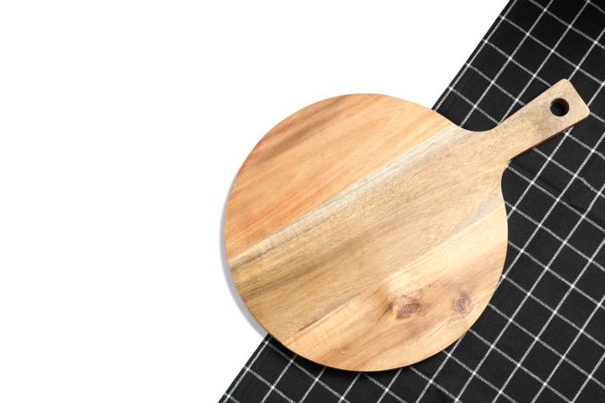 Cutting board with kitchen towel isolated on studio background, top view