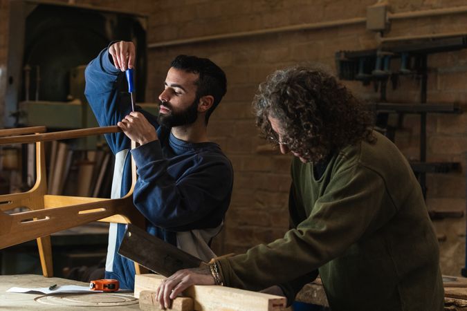 Male artisans creating wooden furniture in workshop