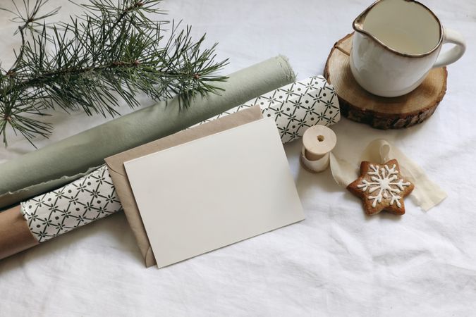 Greeting card, invitation mockup with gingerbread cookies, pine tree branches on linen table cloth