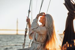 Relaxed older woman sweeping her hair back on a boat
