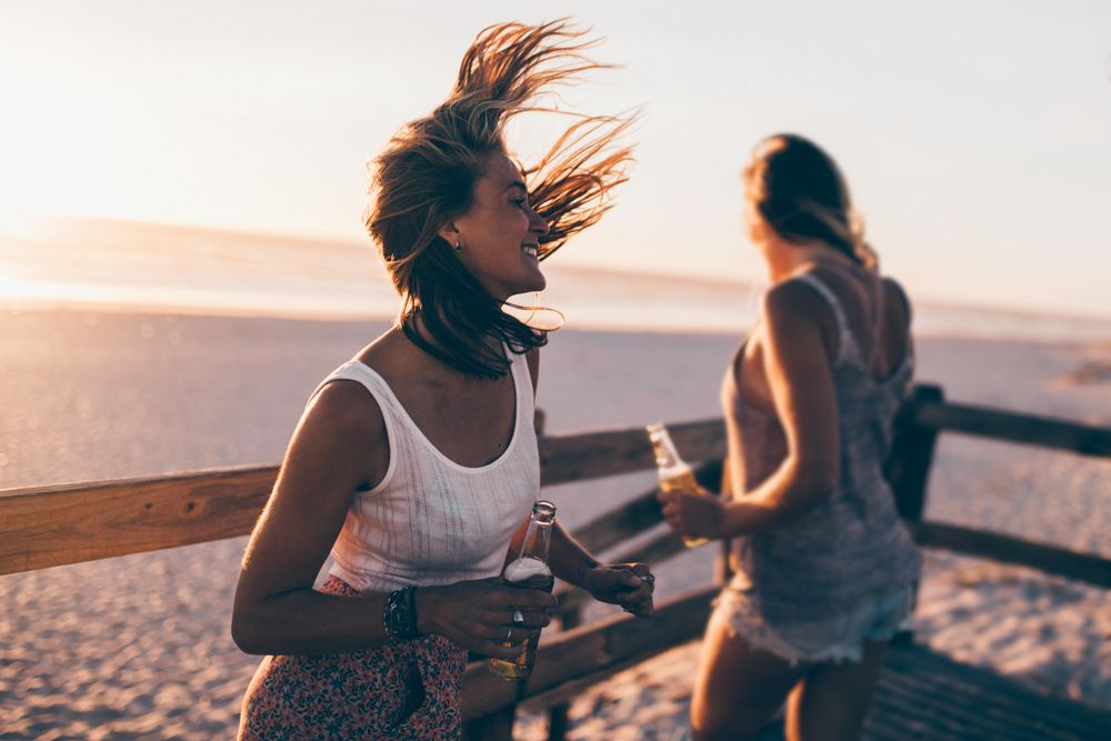 Young women drinking beer at the beach