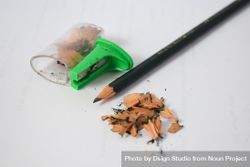 Sharpened pencil on table with shavings & sharpener 56Gv9Y