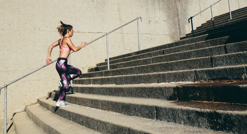 Fitness woman running up on steps