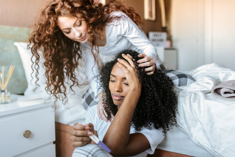 Friend comforting a woman displeased with pregnancy test