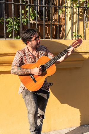 Street Musician playing guitar on the city streets at sunset