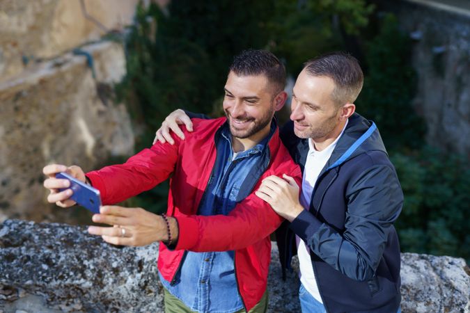 Two happy men taking selfie outside