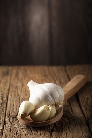 Garlic bulb and garlic cloves on the wooden table.