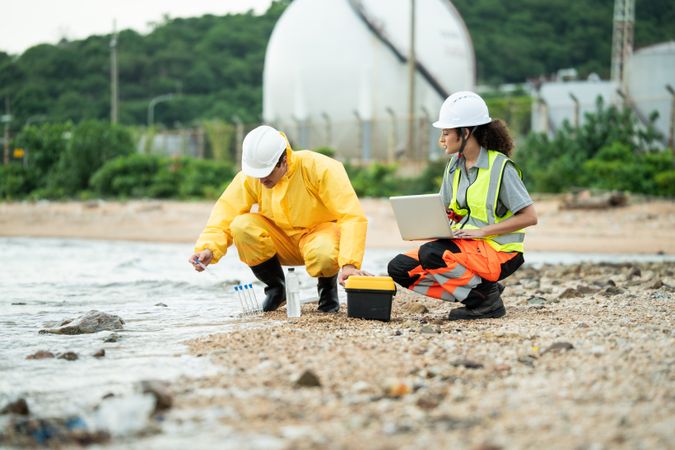 Environment scientist with team analysing waste water collecting sample for research