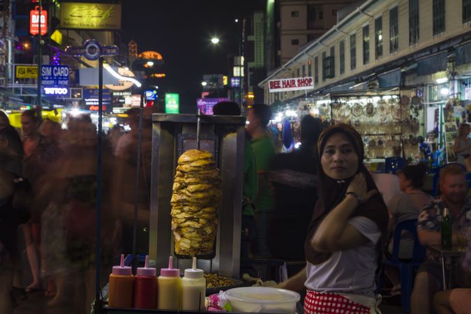 Bangkok, Thailand - January 22, 2020: Woman working at a food stand on busy Khaosan road