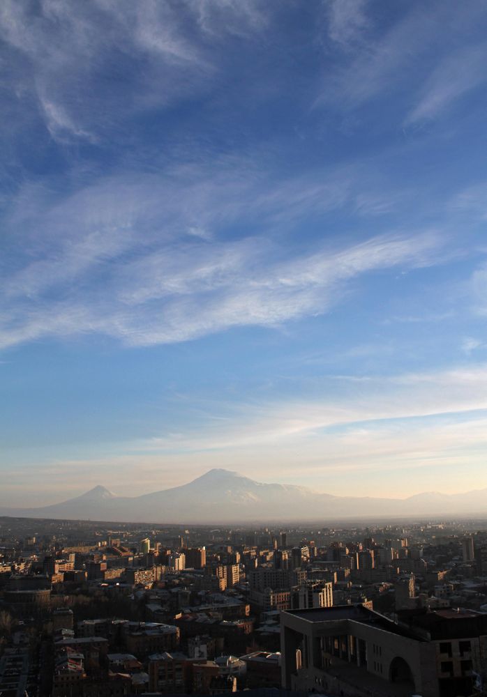Cityscape near mountainous landform under blue sky