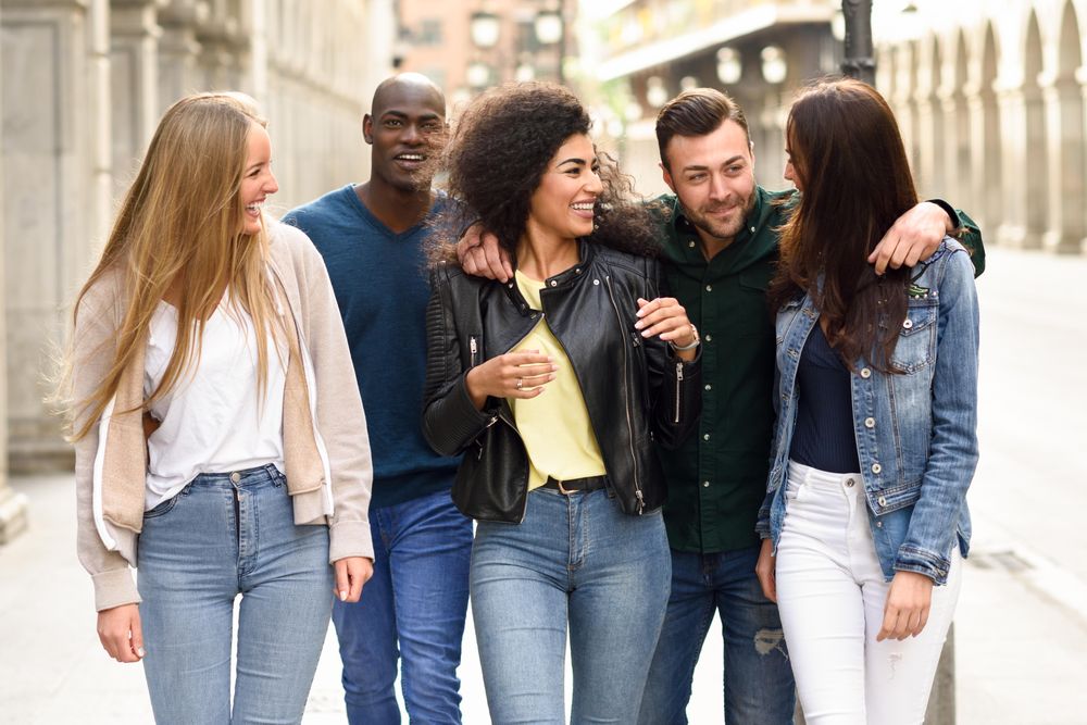 Happy group of friends walking down city street