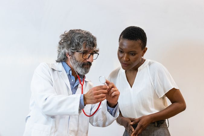 Doctor showing stethoscope to patient