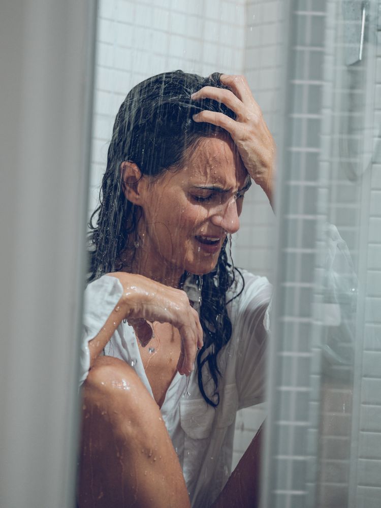 Frustrated female in shirt in shower