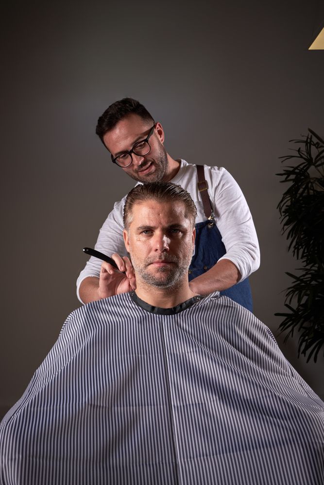 Barber shaving neck of man