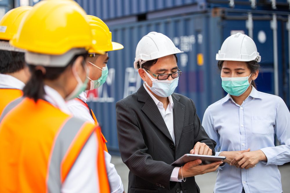 Management discussing plans with onsite construction workers