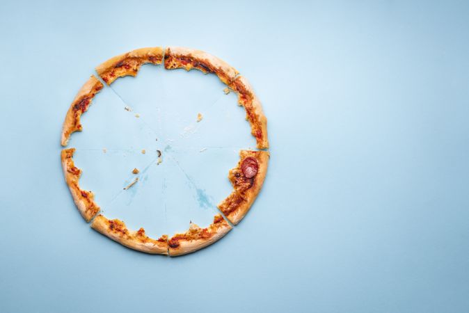 Pizza crust leftovers on blue paper background
