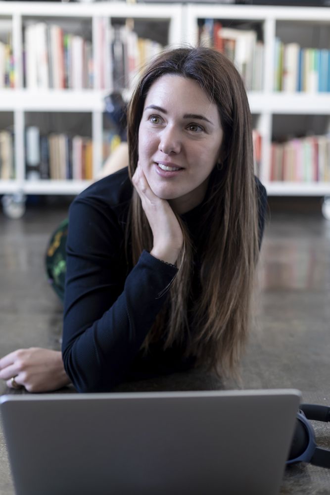 Young entrepreneurial woman in front of laptop on floor