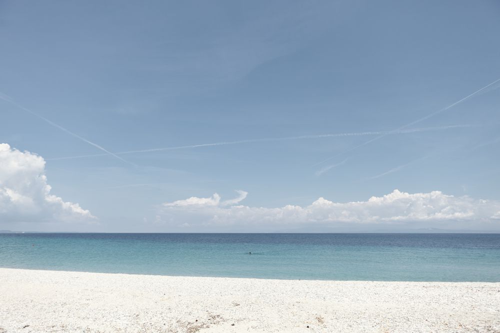 Seascape of white sandy shore and calm water
