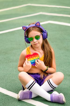 School girl in sunglasses with toy