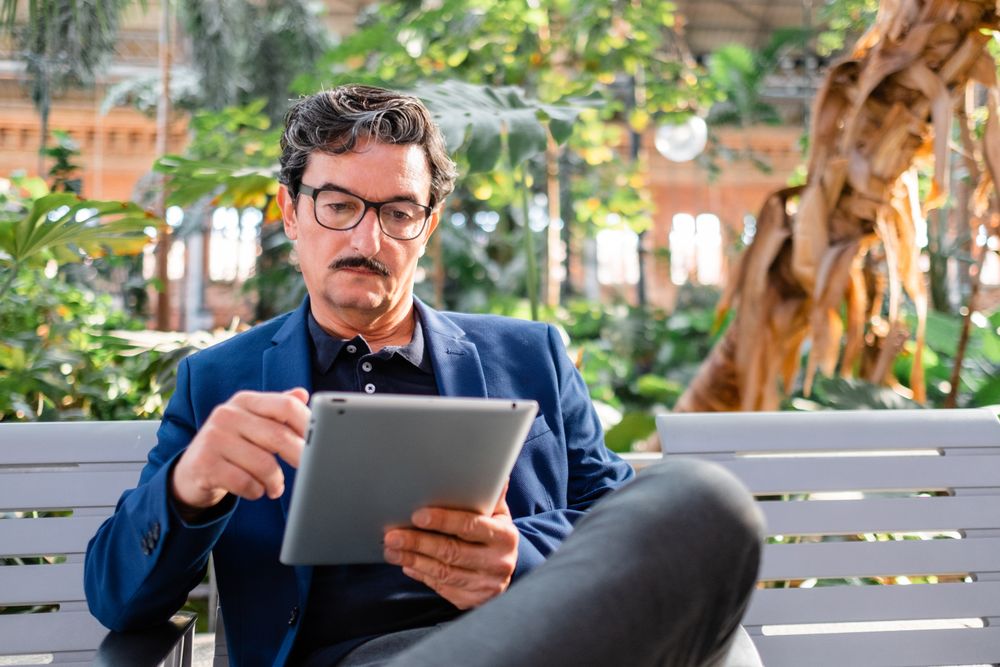 handsome man using digital tablet outdoors