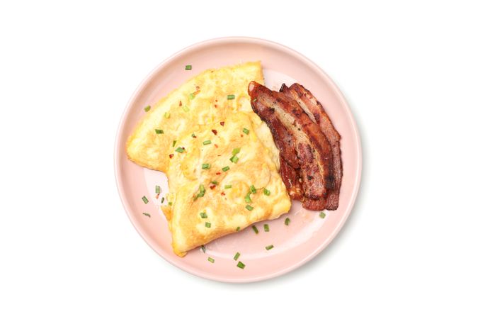 Pink plate with omelette and bacon, top view
