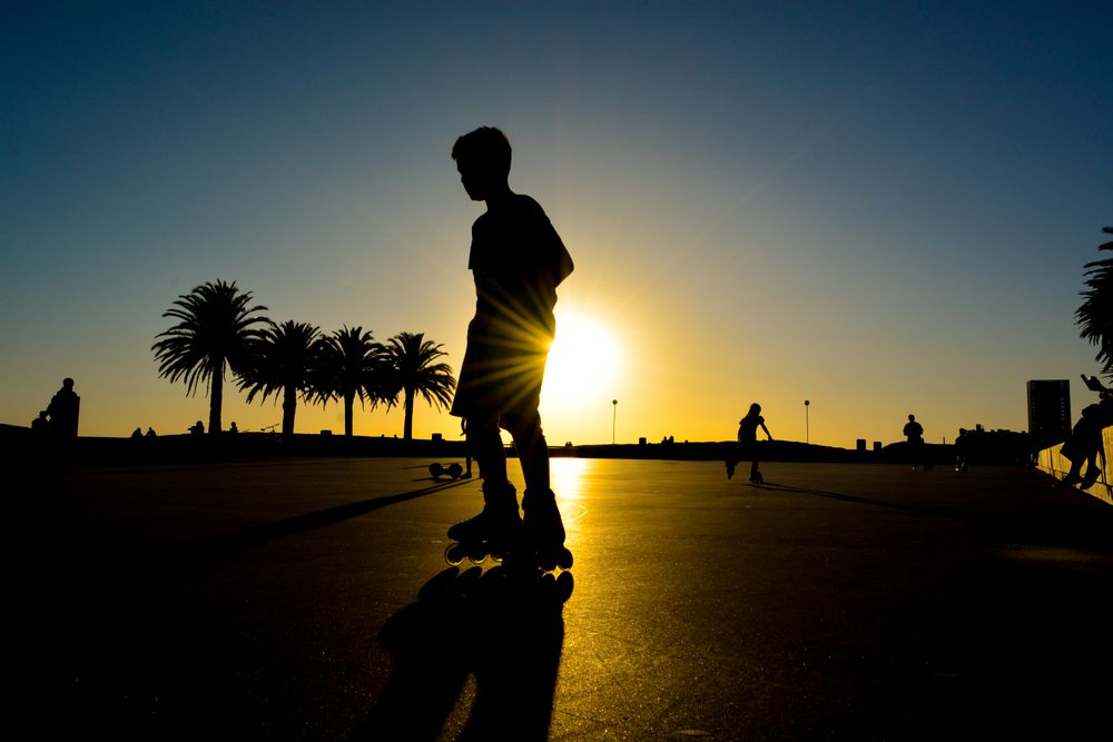 Silhouette of person rollerskating at sunset