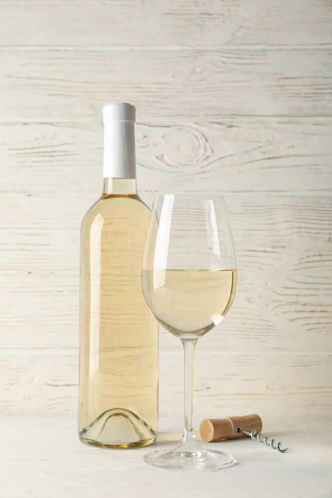 Corkscrew, bottle and glass with wine on blank wooden background, copy space