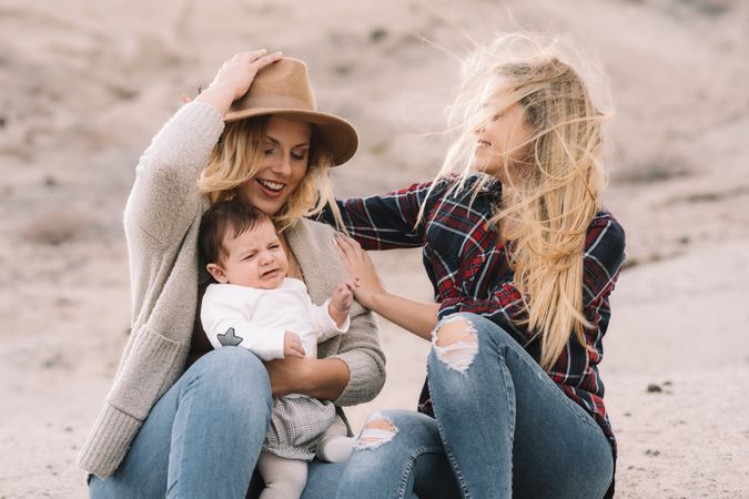 Cheerful women resting with baby on nature