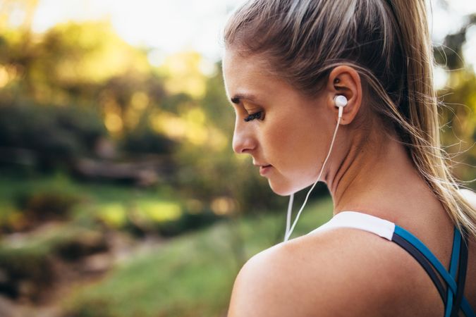 Woman looking down while listening to music during workout