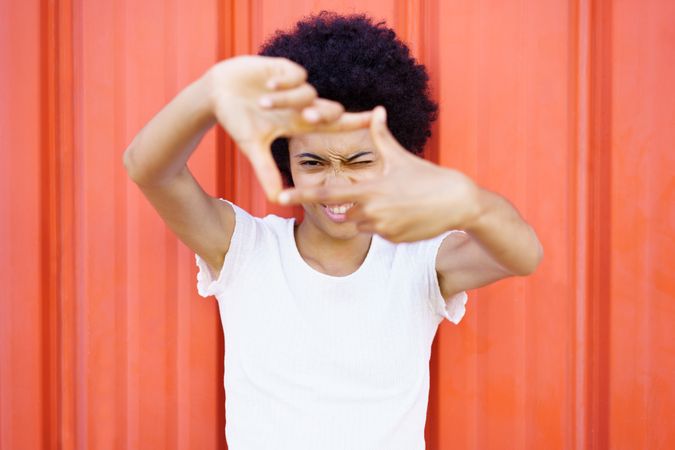 Woman imitating a film director looking through her fingers making a frame