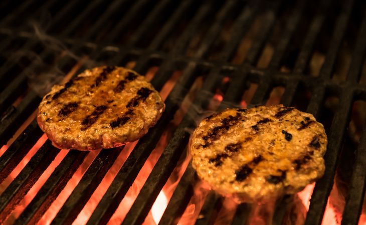 Delicious patties frying on grill