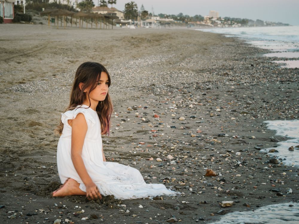 girl sitting on beach in daylight