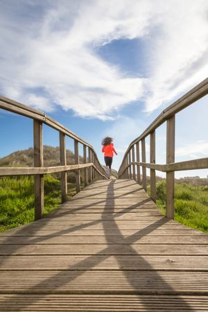 Woman running down wooden path