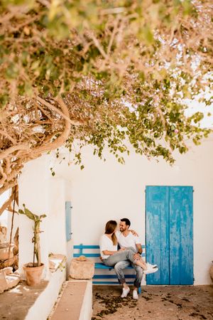 Romantic couple hugging while relaxing on bench at courtyard