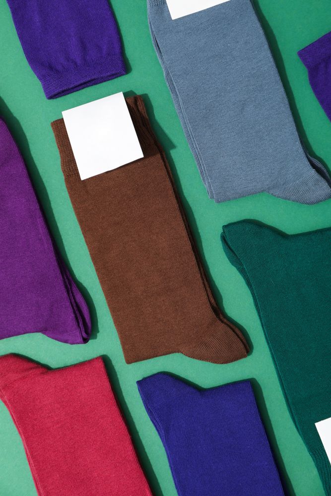 Socks with blank label on green background, space for text