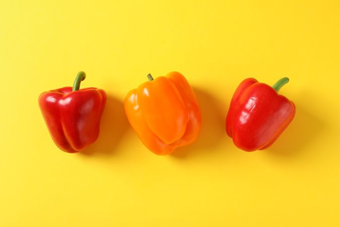 Bell peppers on yellow background, space for text