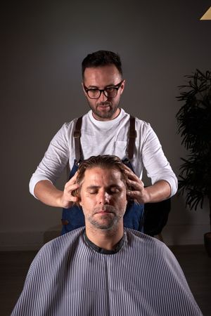 Barber massaging head of client