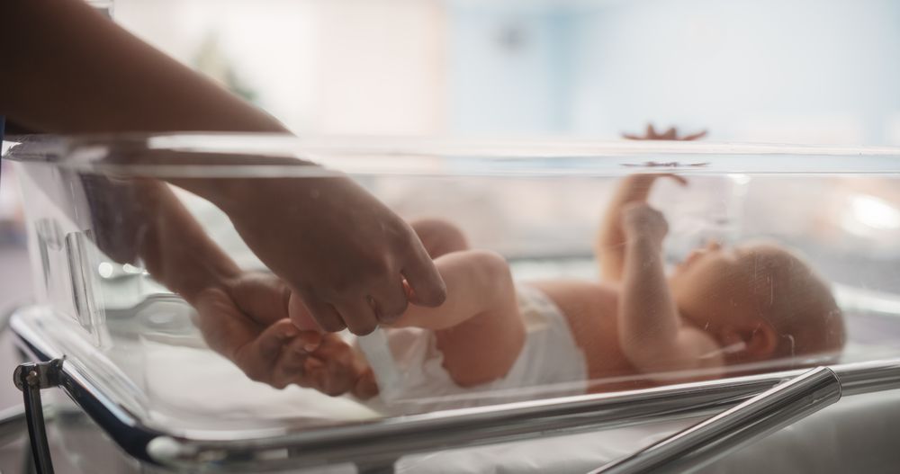 Nurse Putting Identification Hospital Name Tag on a Newborn Child.