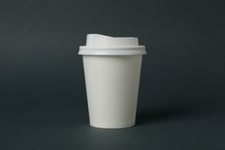 paper cup on light dark background, space for text