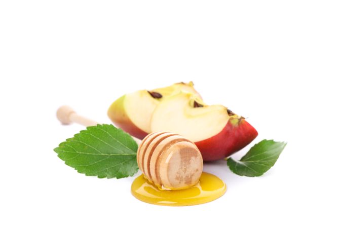 Apple pieces, leaves and dipper with honey isolated on neutral background