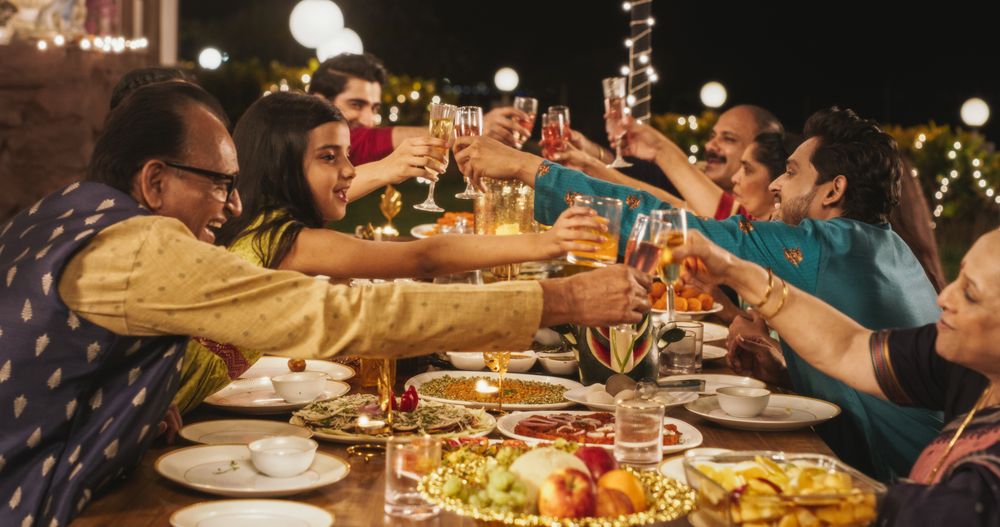Happy Indian Family Having a Feast and Celebrating Diwali Together: Group of People of Different Ages in Their Traditional Clothes
